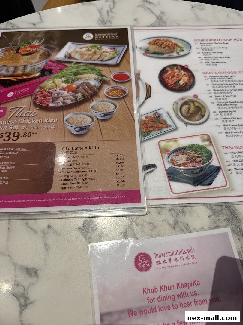 A menu from Go-Ang Pratunam Chicken Rice featuring Thai dishes and a hot pot set.