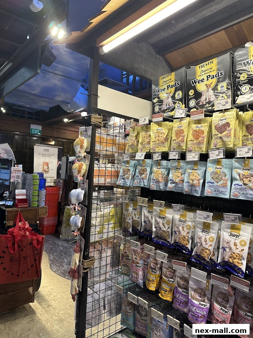 A well-stocked pet store aisle featuring various pet food and supplies, including treats and pads.