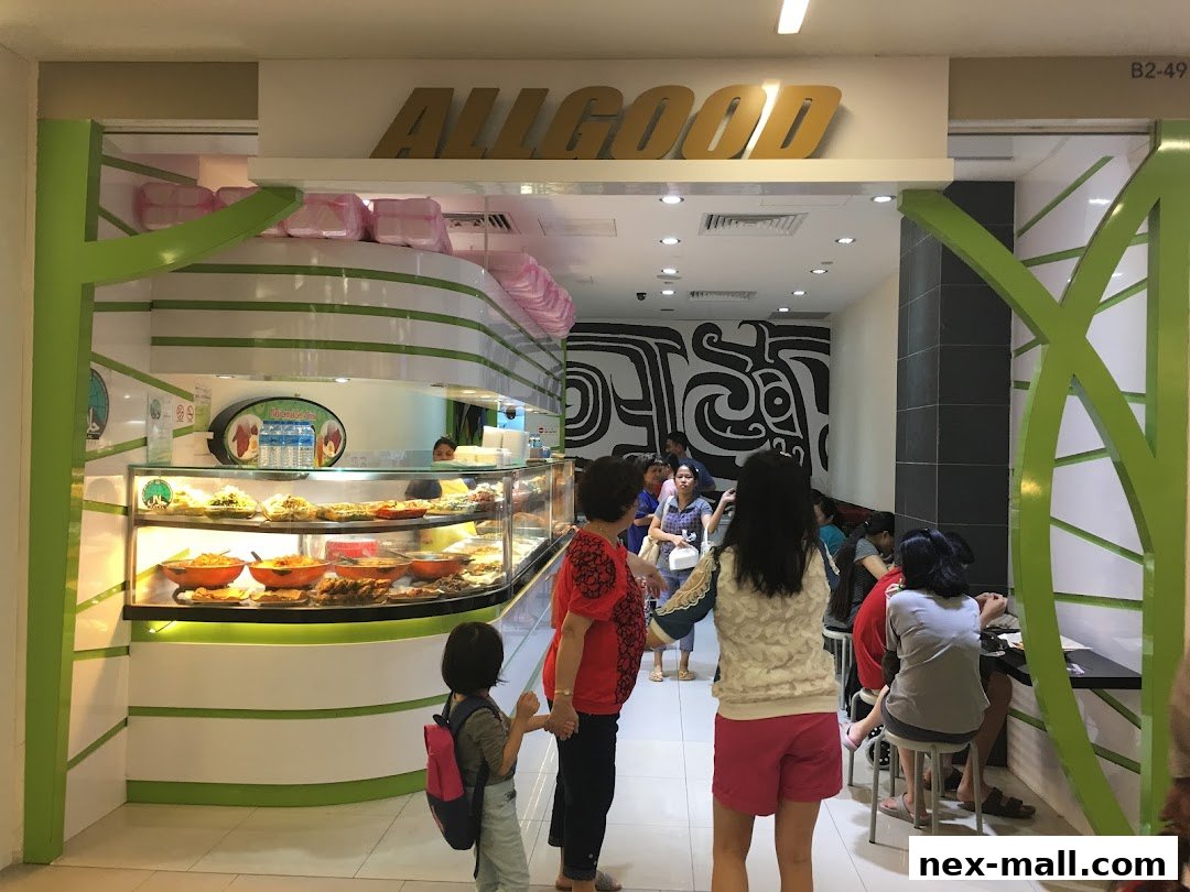 People queuing at a food stall with a display of various dishes.