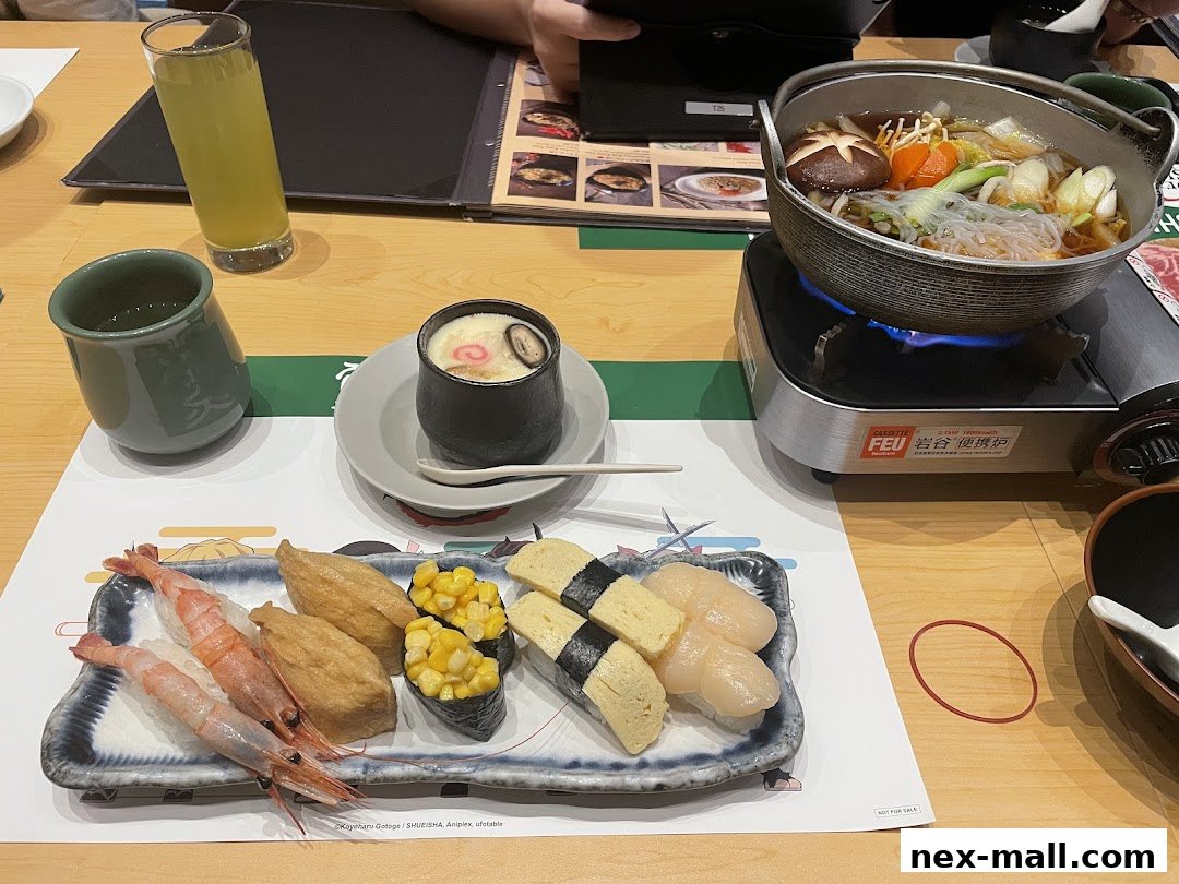 A table setting at Sushi Tei with various sushi, a hot pot, and drinks.