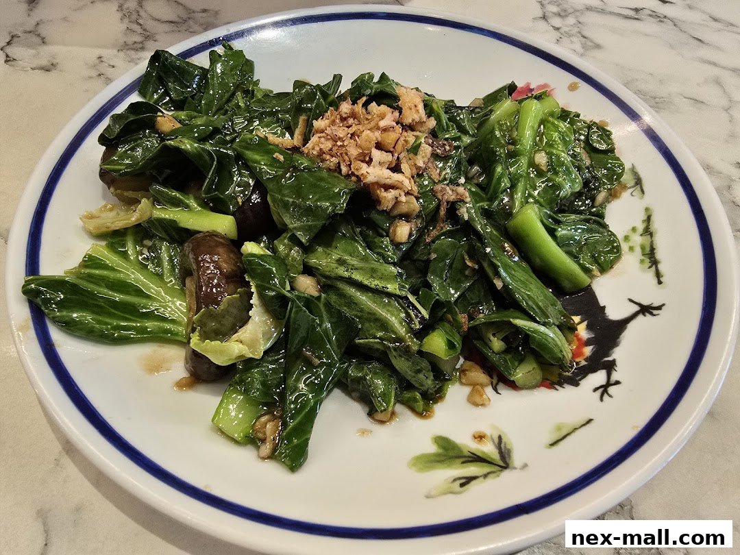 A plate of stir-fried Chinese broccoli with mushrooms and crispy garlic.