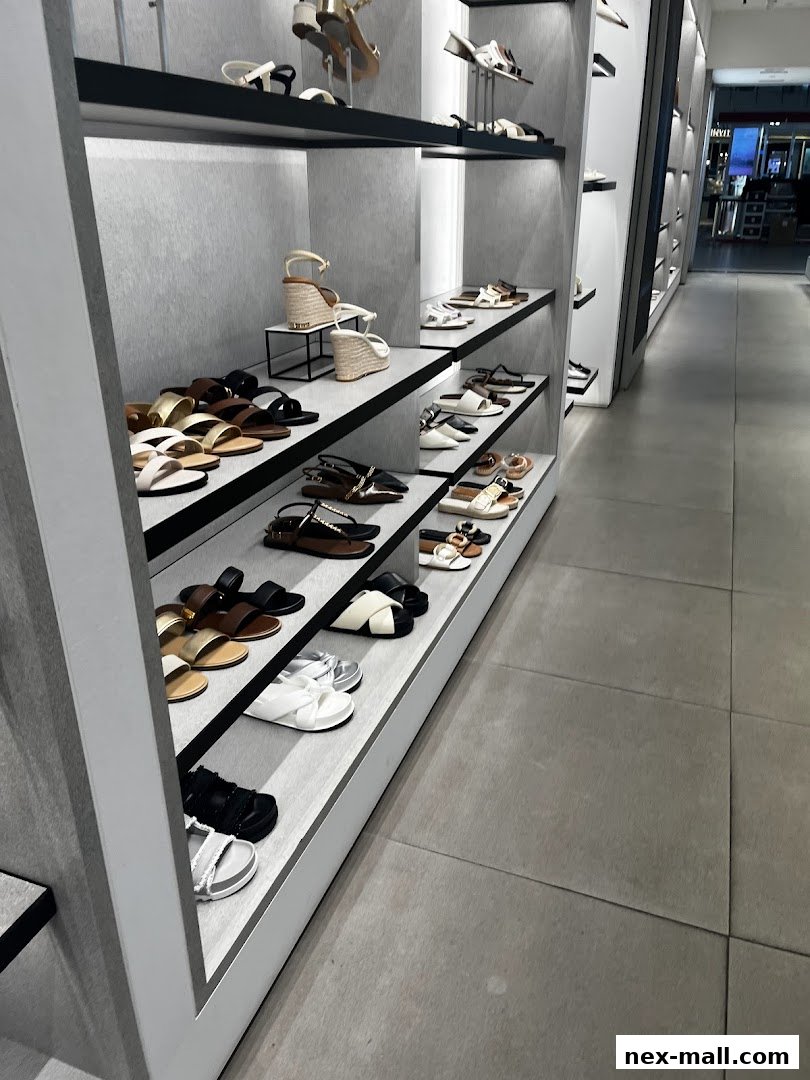 A well-lit interior view of a Charles & Keith store showcasing a variety of stylish women's sandals on display shelves.
