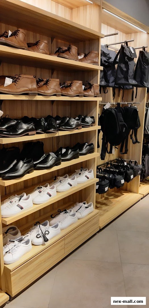 Shelves display various men's shoes and backpacks in a retail store.