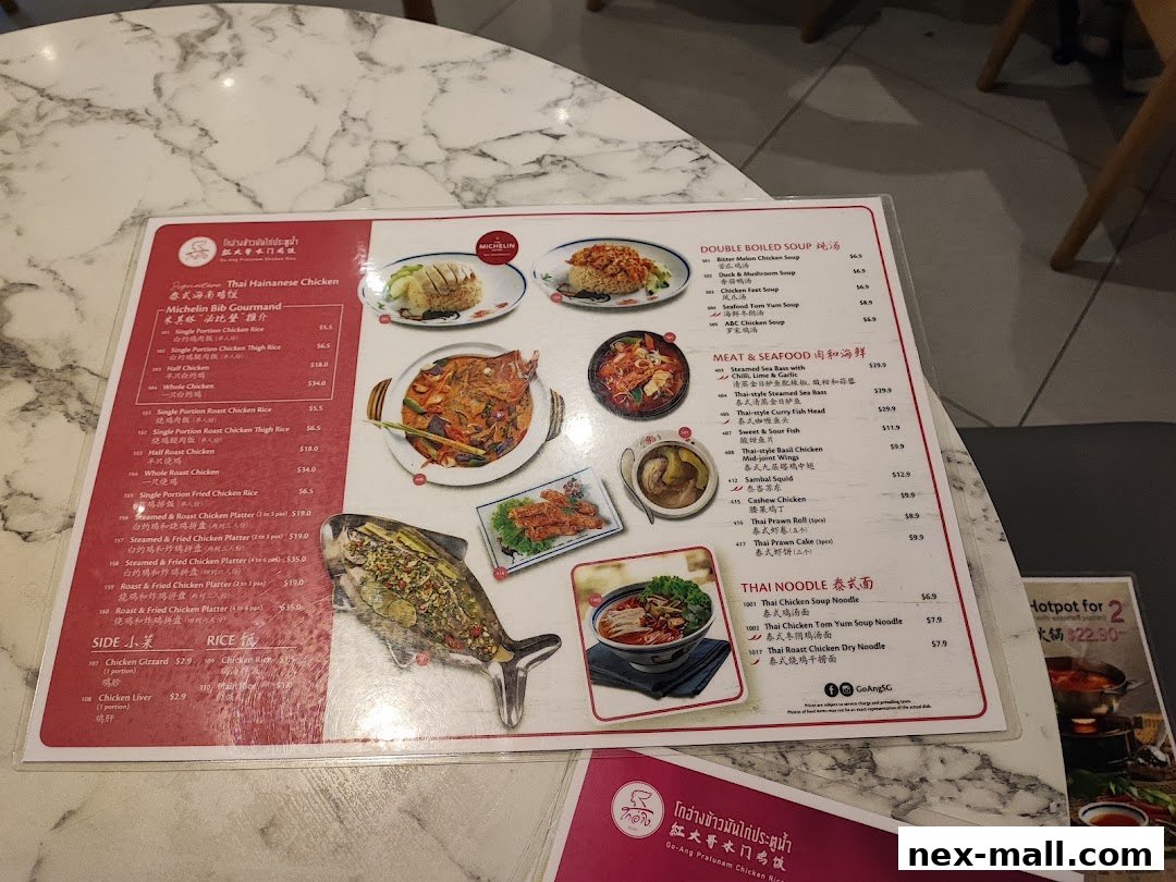 A menu from Go-Ang Pratunam Chicken Rice featuring various chicken dishes, soups, seafood, noodles, and sides.