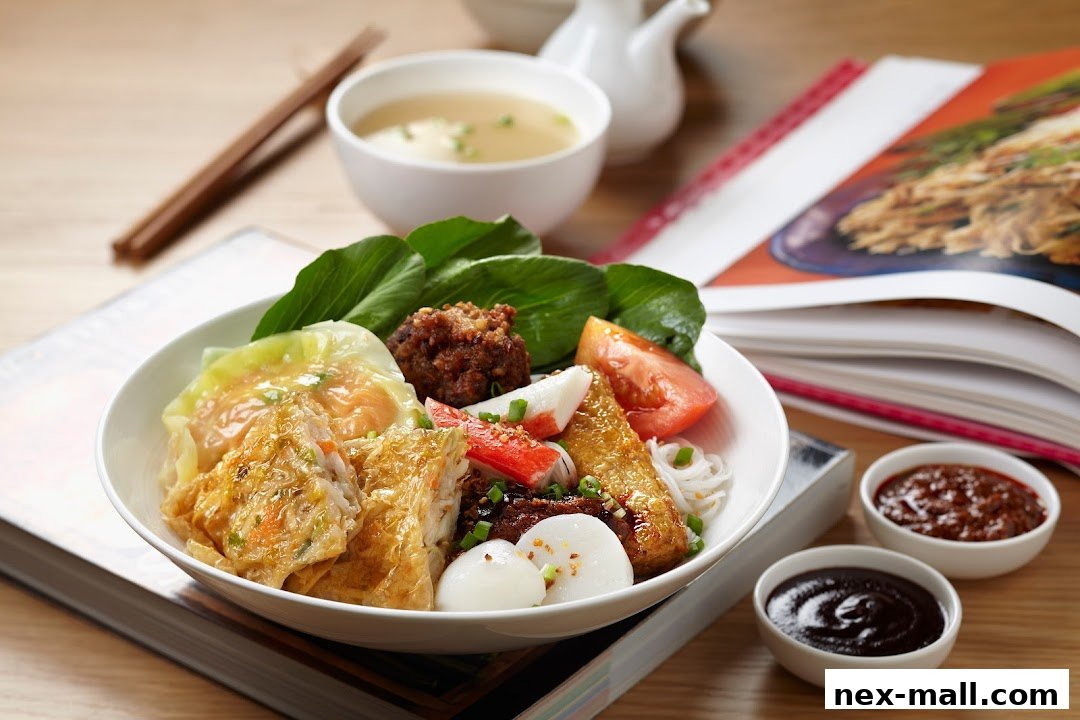 A bowl of noodles with various toppings, served with soup and dipping sauces.