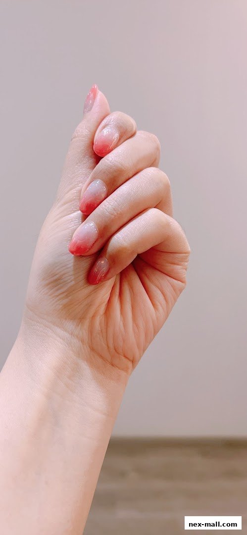 A close-up shot of a hand with a beautiful ombre nail design.