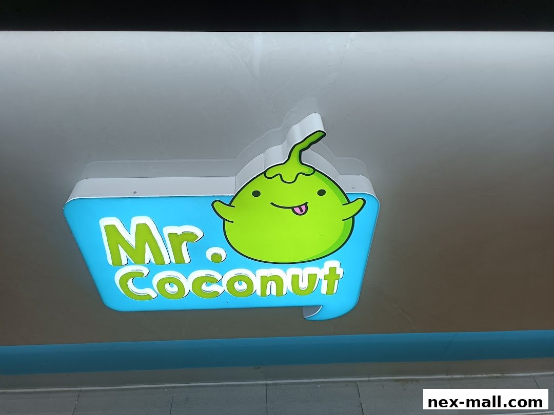 A brightly lit sign for 'Mr. Coconut' featuring a cute cartoon coconut character.