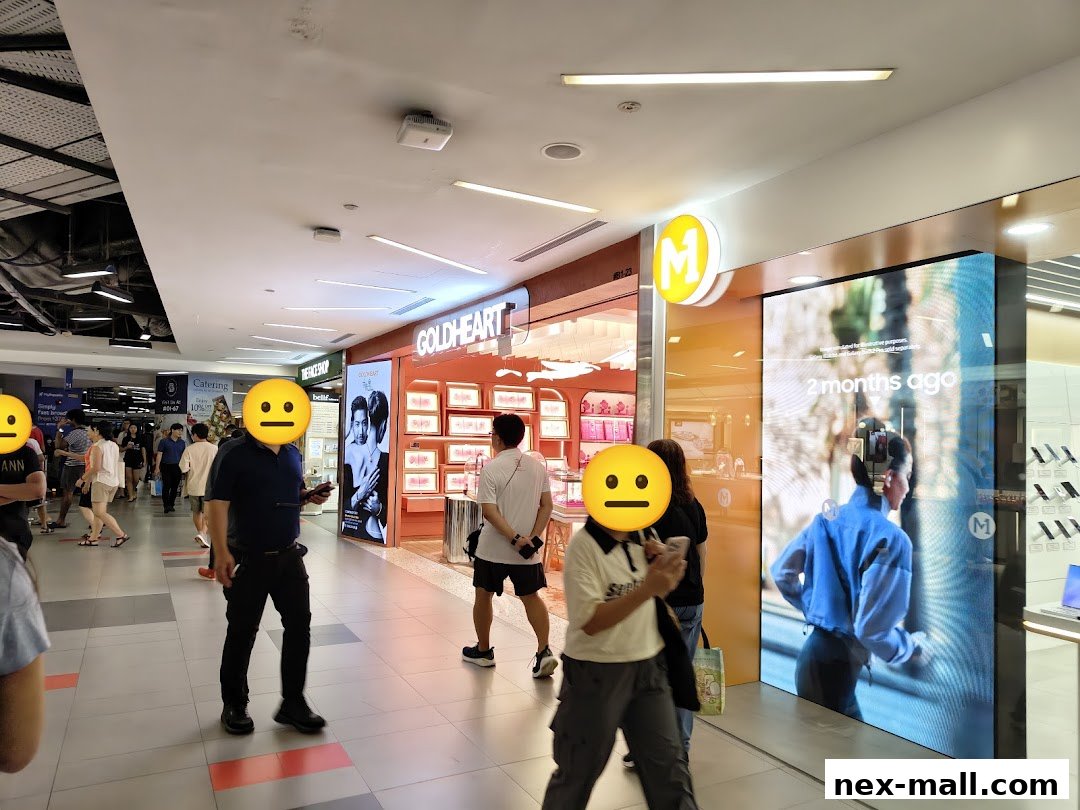 A Goldheart Jewelry store with illuminated displays and shoppers in a mall.