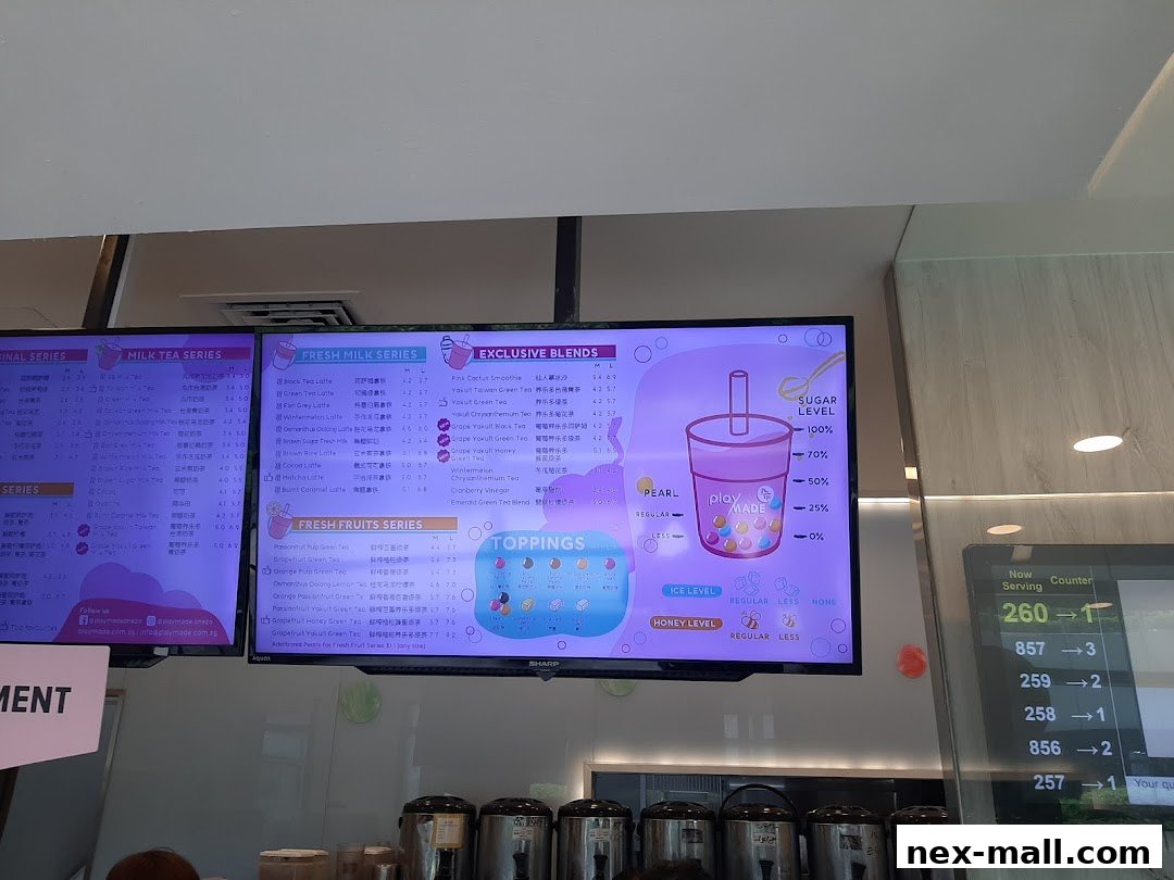 A digital menu board displaying various milk tea and fruit tea options with prices.