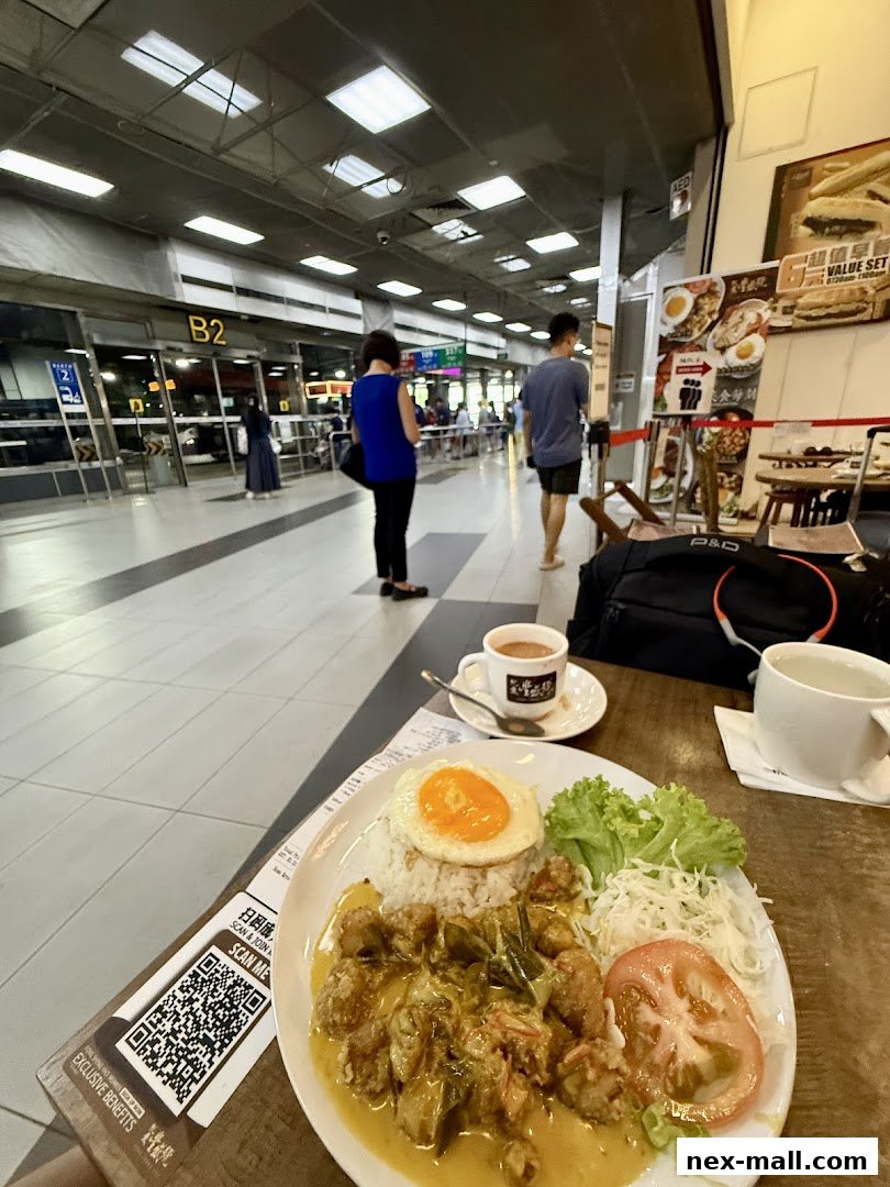A plate of food with rice, fried chicken, and a fried egg, next to a cup of tea.