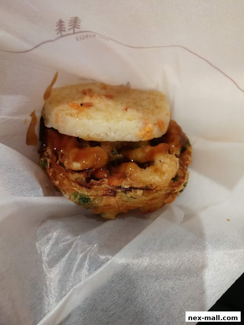 A close-up of a delicious MOS Burger with rice buns and savory filling.