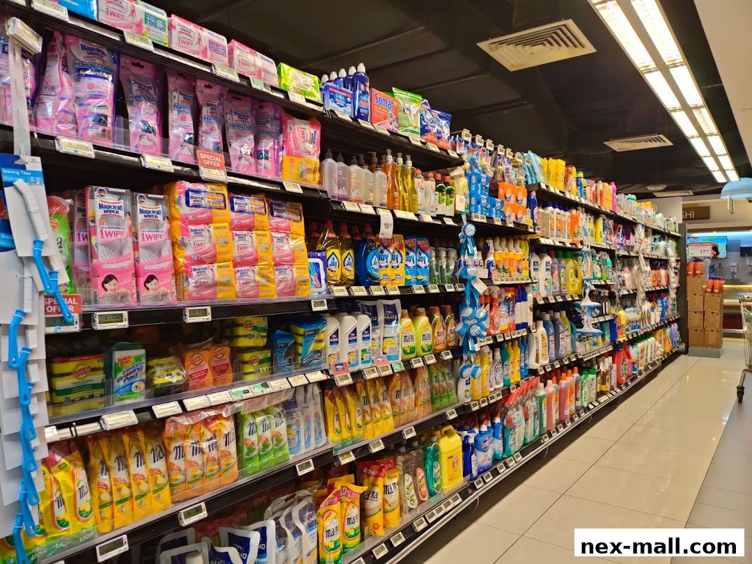 A wide aisle in a supermarket stocked with cleaning supplies and household products.