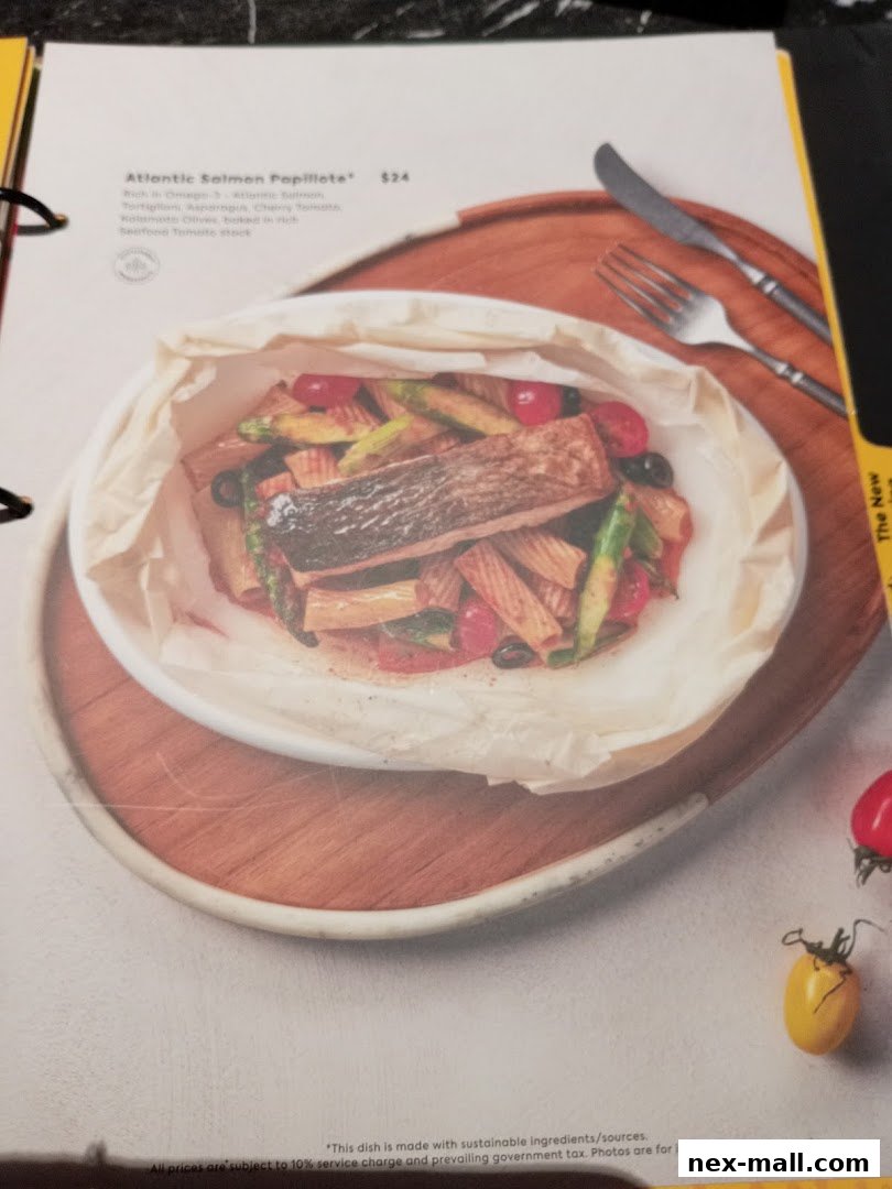 A menu item featuring Atlantic Salmon Papillote with pasta and vegetables.