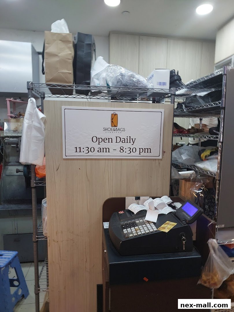 A shop counter with a cash register and a sign indicating operating hours.