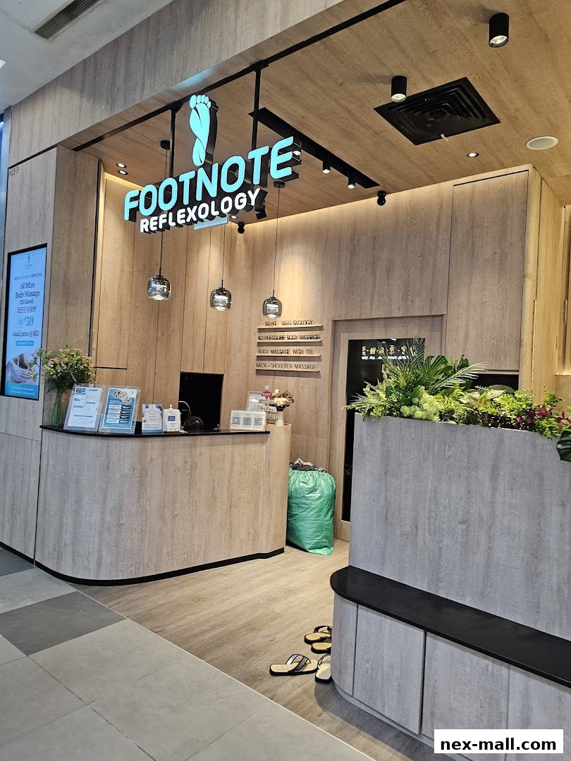The entrance of FootNote Reflexology with its illuminated sign and reception counter.
