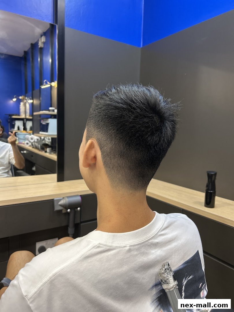 A person receiving a fresh haircut at Clippers Barber NEX.