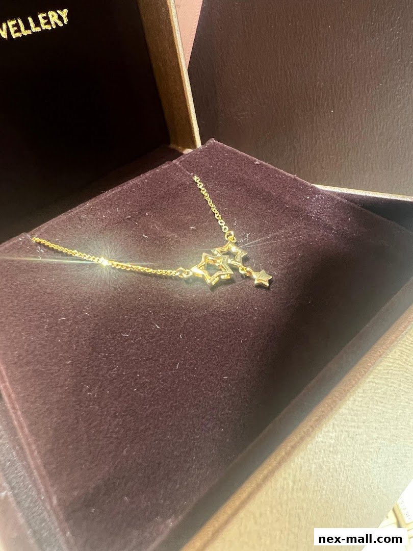 A delicate gold necklace with star charms displayed in a jewelry box.