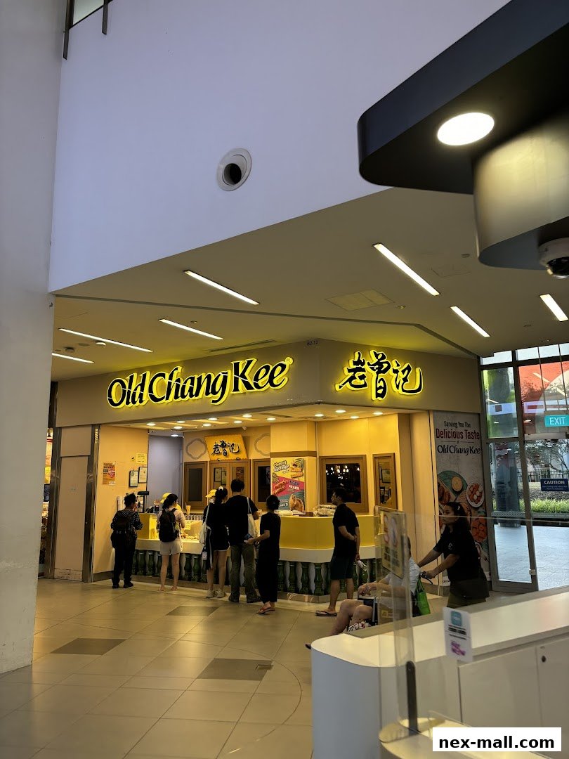 People queuing at the Old Chang Kee shop entrance with bright yellow signage.