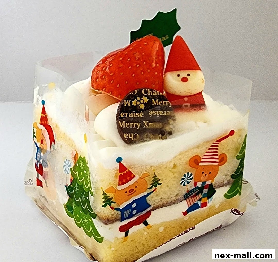 A festive Christmas cake slice decorated with a strawberry, Santa figure, and cute animal characters.