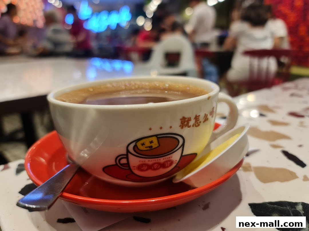 A close-up of a cup of coffee with a cartoon design and Chinese text, served with a small dish of butter.