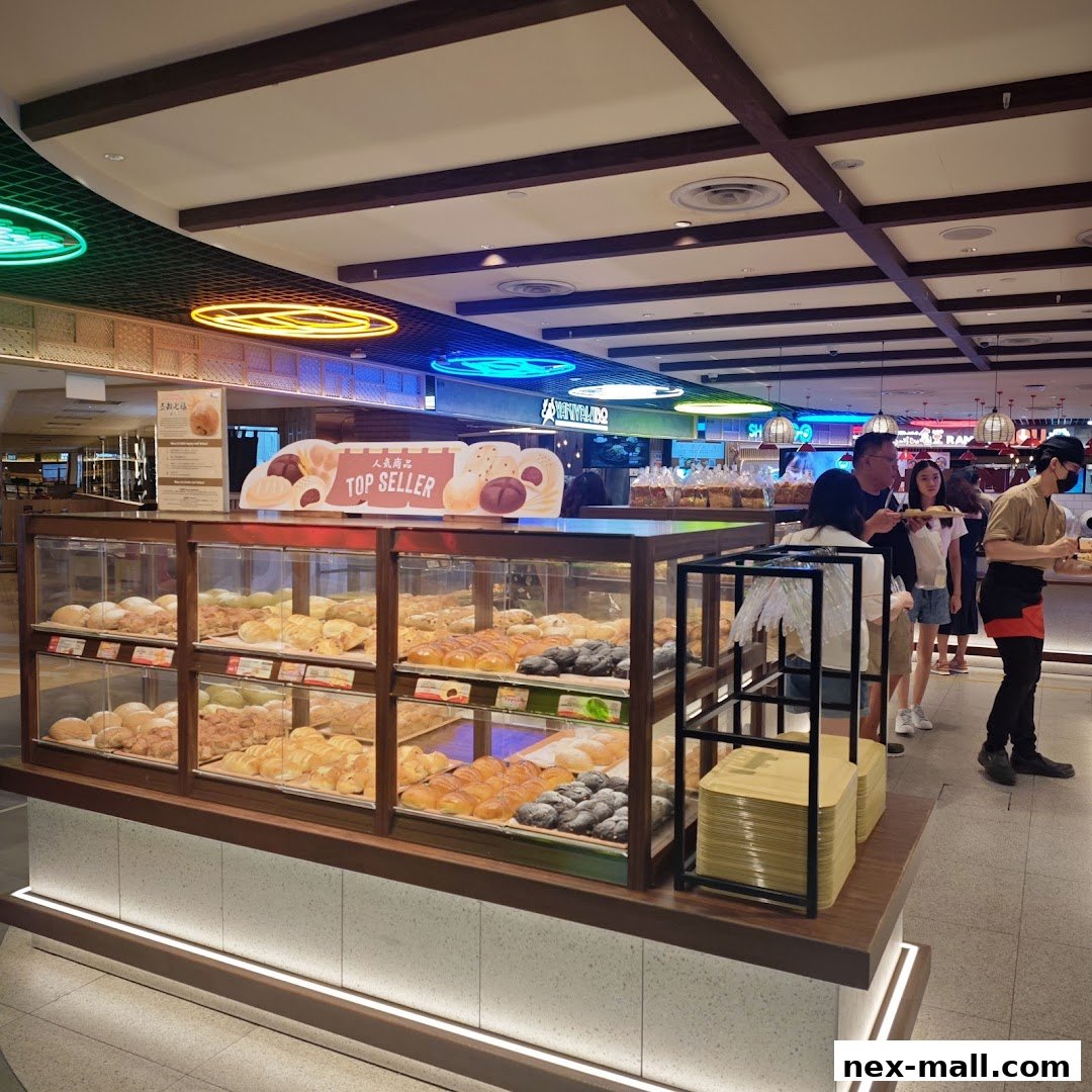 A display case filled with various baked goods, with customers queuing to purchase them.