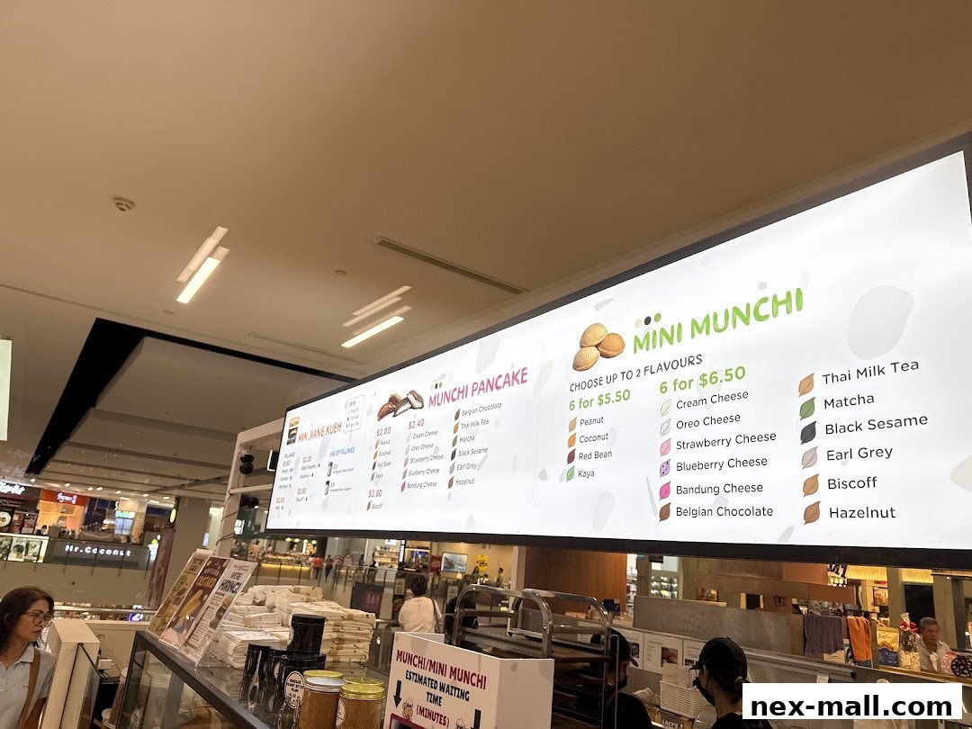 A brightly lit menu board for Munchi Pancakes and Mini Munchi with various flavors and prices.