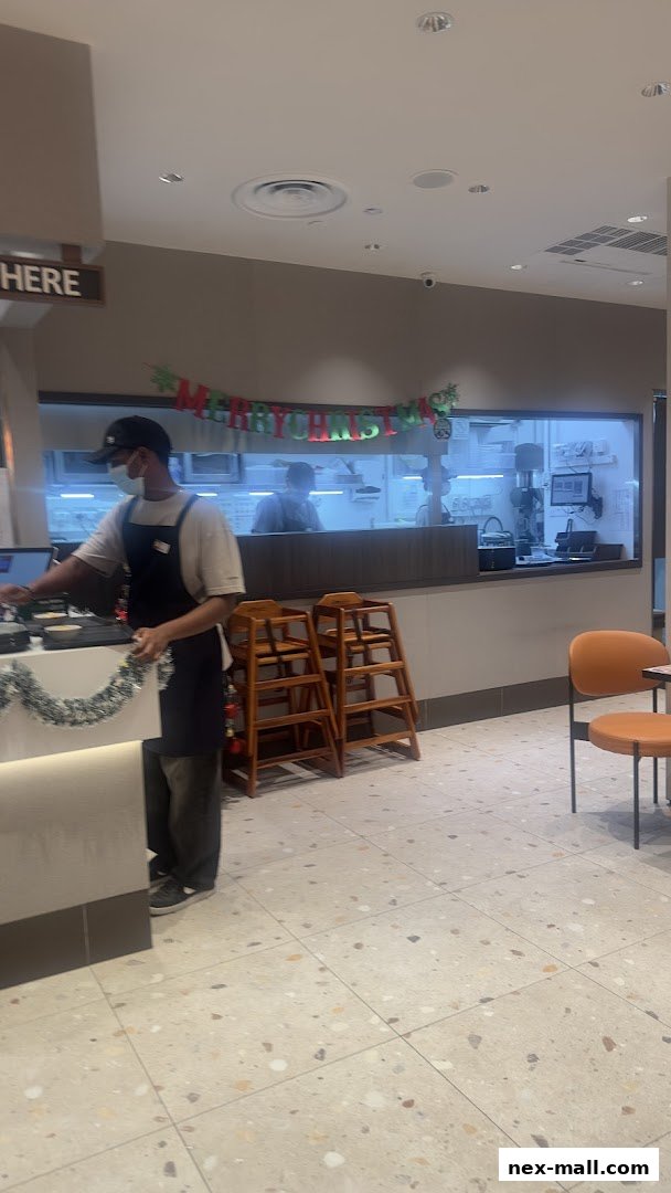 A staff member is preparing the counter with festive decorations at Pepper Lunch Express.