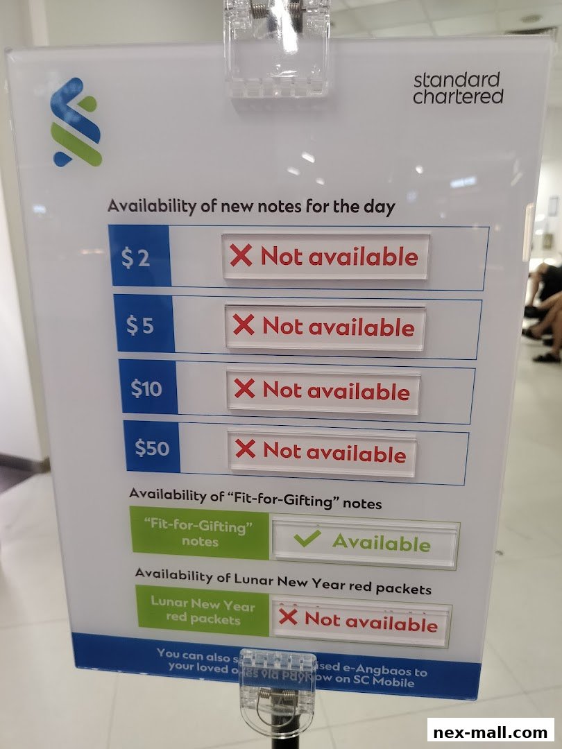 A sign at Standard Chartered Bank ATM NEX showing availability of new notes and red packets.