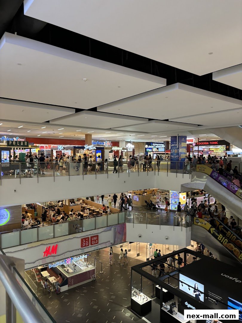 A multi-level shopping mall interior with various shops and escalators.