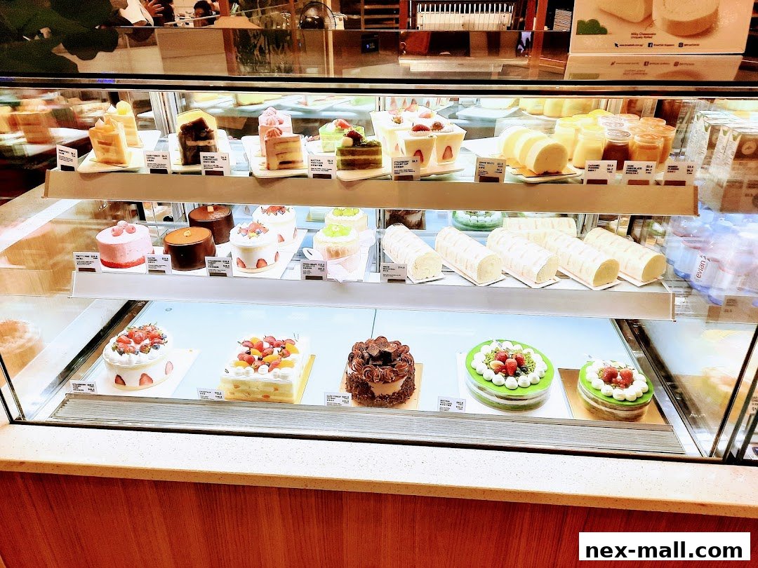 A display case filled with a variety of beautifully decorated cakes and pastries.