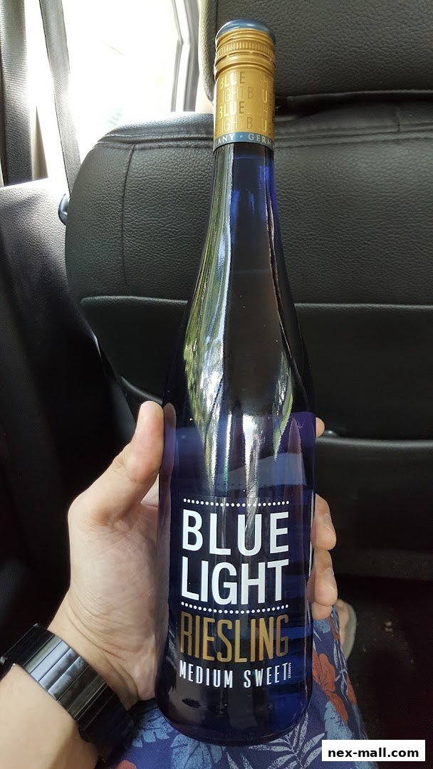 A person holds a bottle of Blue Light Riesling wine, made in Germany.