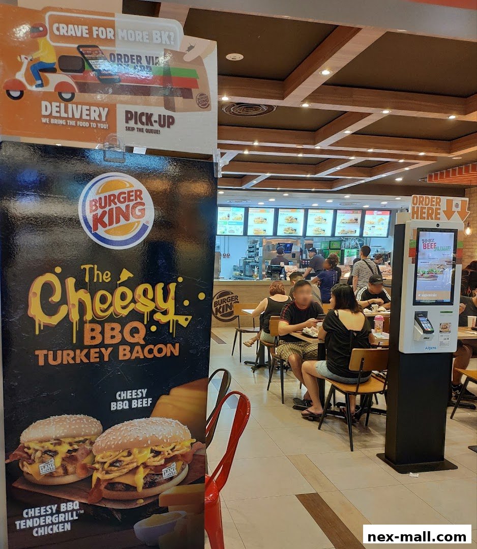 Burger King restaurant interior with customers dining and a promotional poster for Cheesy BBQ Turkey Bacon.