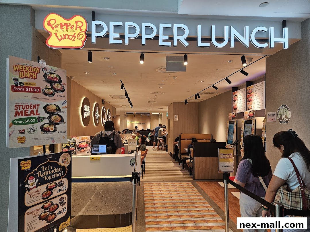 The entrance of Pepper Lunch restaurant with promotional posters and customers waiting.