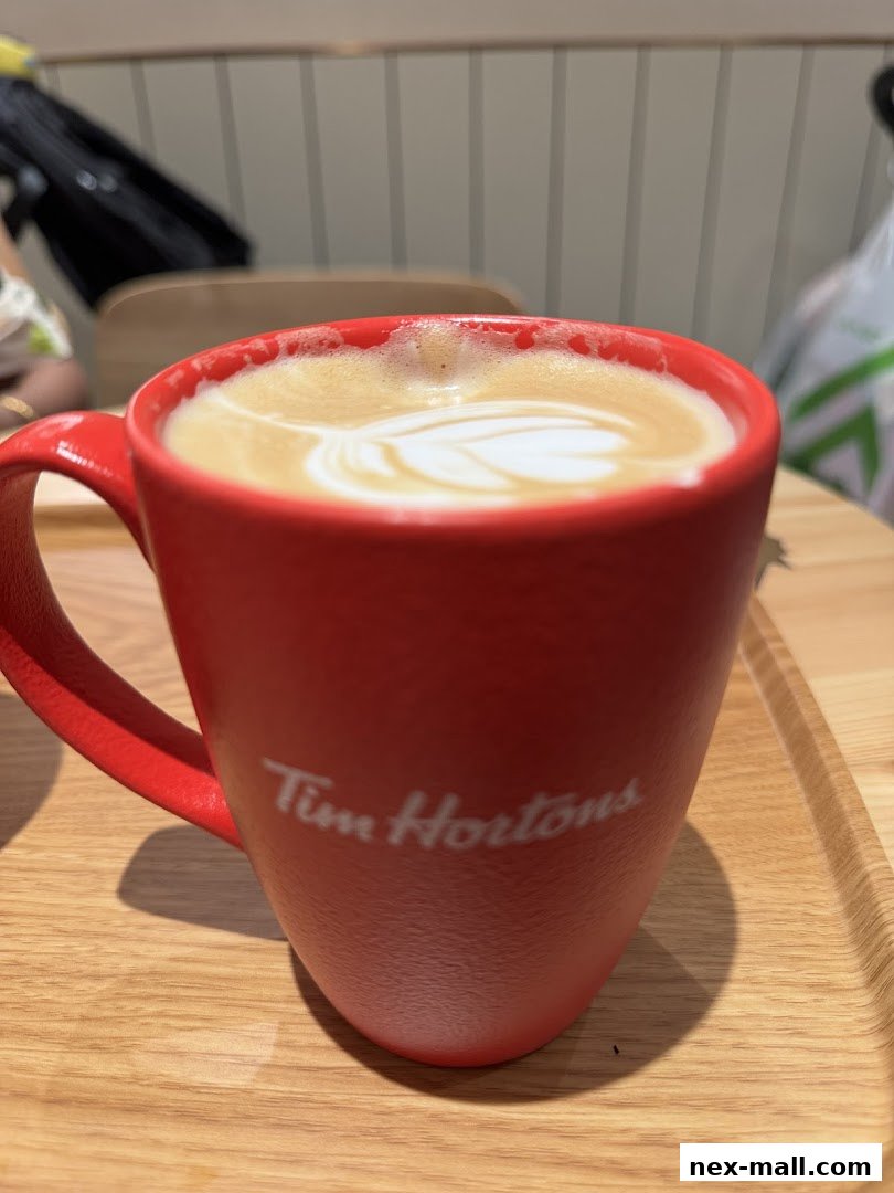 A close-up of a red Tim Hortons mug filled with a latte with art.