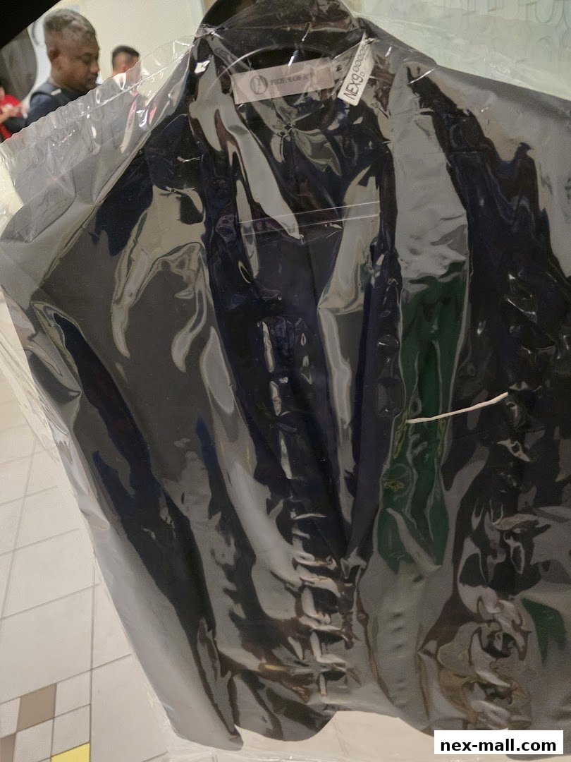 A dark suit jacket is neatly packaged in clear plastic, ready for collection.