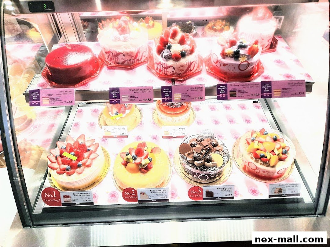 A display case filled with various beautifully decorated cakes and pastries.