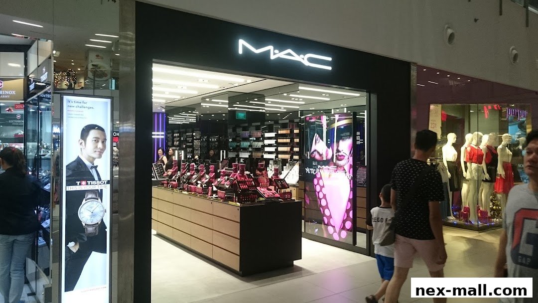 The MAC Cosmetics store entrance with makeup displays and promotional visuals.