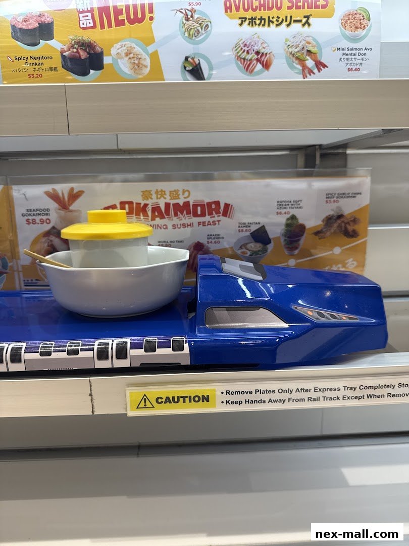 A conveyor belt sushi train with various sushi dishes and a caution sign.