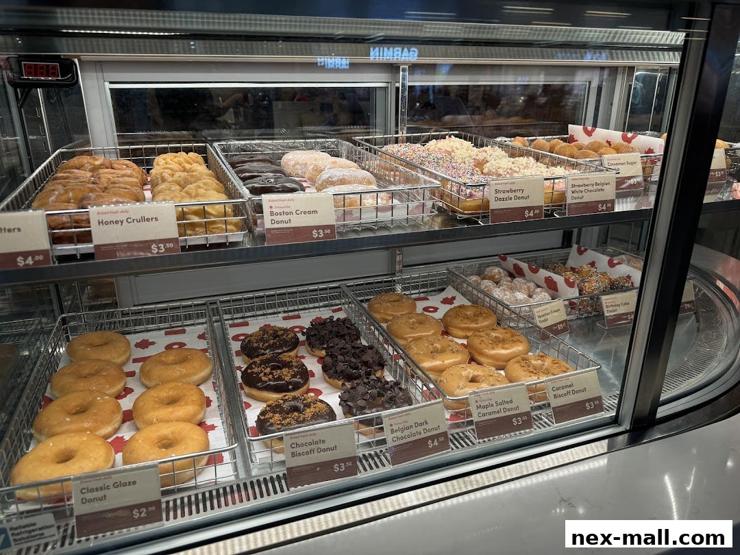 A display case filled with a variety of freshly baked donuts at Tim Hortons.