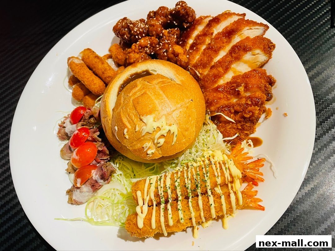 A platter of assorted fried foods including chicken, shrimp, cheese sticks, and a bread bowl.