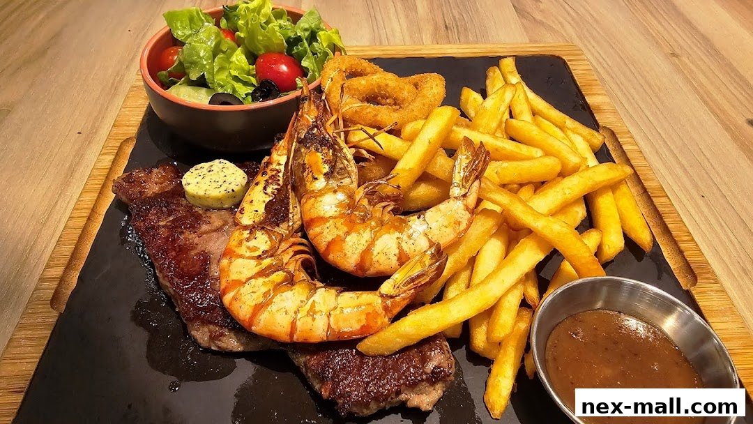 A delicious steak and shrimp platter with fries, onion rings, and a side salad.