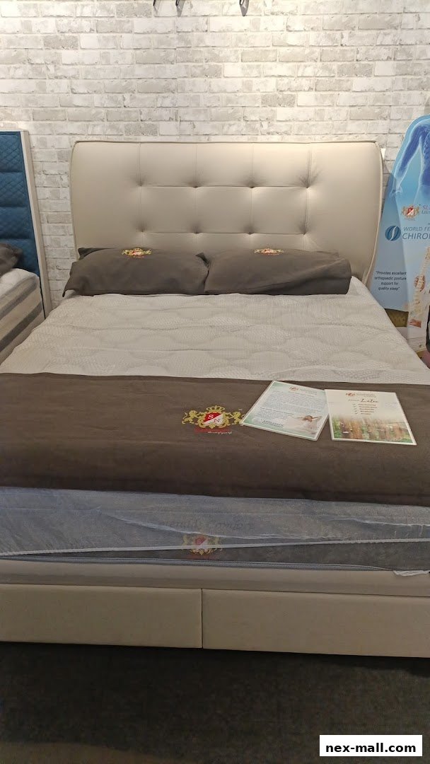 A king-size bed with a beige tufted headboard and brown pillows on display.
