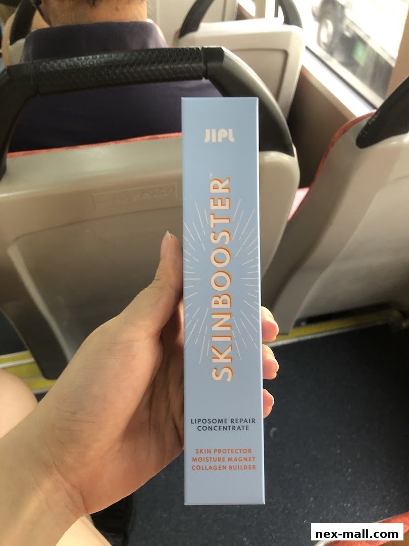 A hand holds a JIPL Skinbooster product box with text about its benefits.