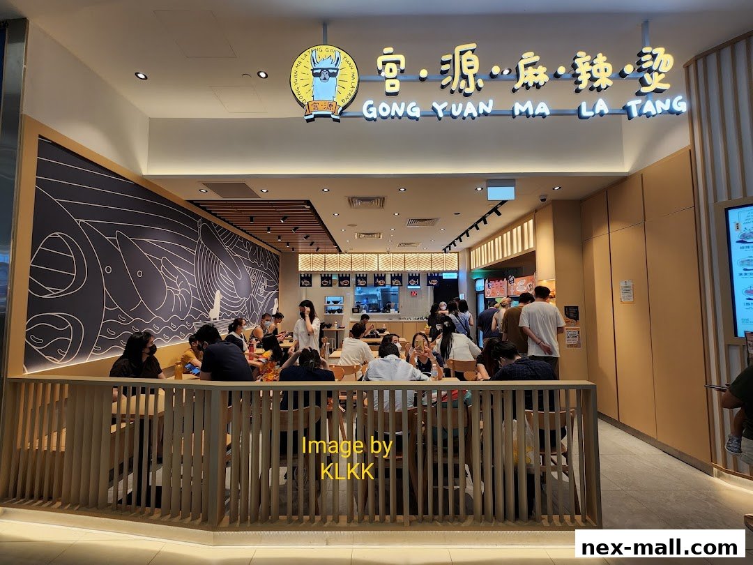 People dining at Gong Yuan Ma La Tang, a restaurant with a modern interior and a distinctive mural.