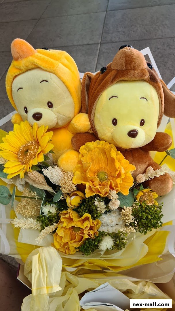 A bouquet featuring two plush toys dressed as animals, surrounded by yellow flowers and dried foliage.