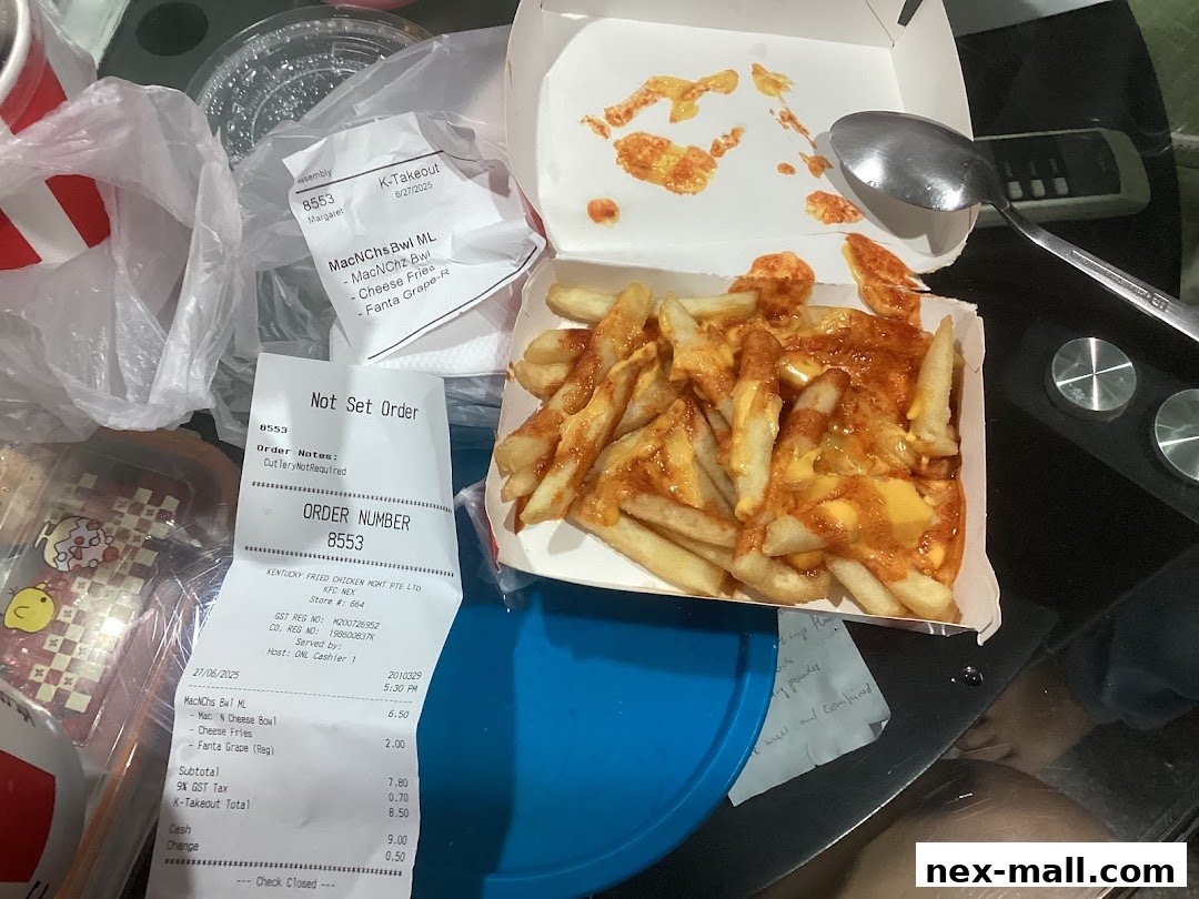 A box of KFC cheese fries and a receipt are on a table.