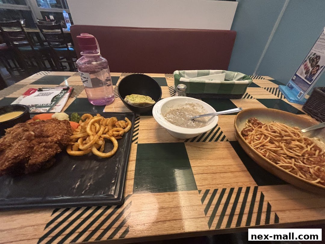 A table setting at Jack's Place with a chicken chop, curly fries, spaghetti, soup, and a bottle of water.