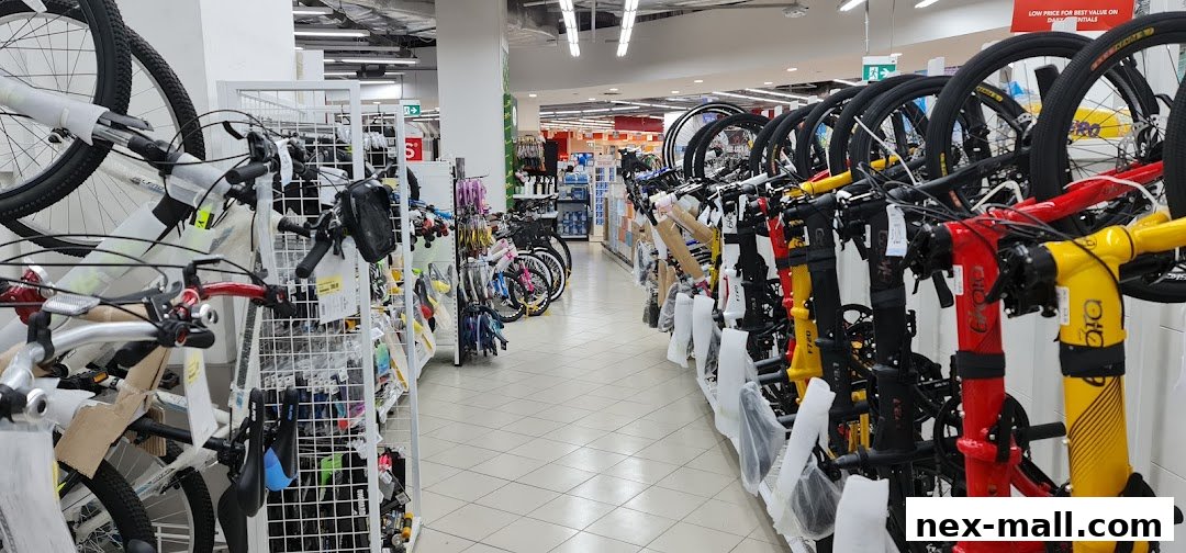Aisle of bicycles for sale in a retail store, with various models and colors displayed.