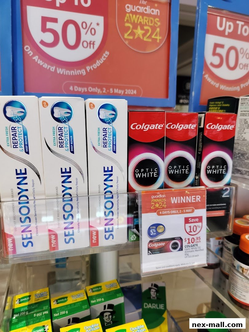 A display of toothpaste products, including Sensodyne and Colgate, with promotional signage.
