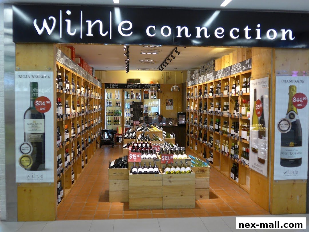A well-stocked wine shop with shelves full of bottles and promotional displays.